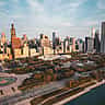 An aerial view of the Chicago skyline and Grant Park bathed in warm golden light.