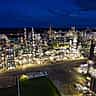 An expansive oil refinery brightly illuminated at night, showcasing the scale of modern energy infrastructure.