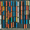 An aerial top-down view of colorful shipping containers arranged in neat rows at a port terminal.