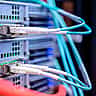 Blue Ethernet cables are connected to the ports of a modern data center server rack.