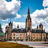 The iconic architecture of Parliament Hill in Ottawa, Canada, standing against a vibrant sky.