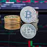 Gold Bitcoin tokens stacked in front of a digital financial trading chart.