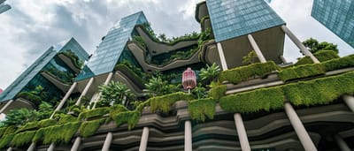 A striking modern skyscraper integrates lush vertical gardens and cascading plants into its eco-friendly architectural design.