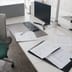 Official business forms and documents arranged neatly on a modern office desk next to a computer monitor.