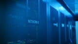 A row of modern server racks illuminated with blue light in a large data center.