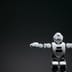 A sleek white humanoid robot with glowing blue eyes stands against a dark background.
