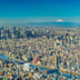 A sprawling panoramic view of the Tokyo city skyline on a clear day with Mount Fuji visible in the distance.