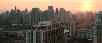 A vibrant sunset over the modern skyscraper skyline of Taguig City, home to the Philippine Stock Exchange.