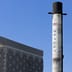 A SpaceX Falcon 9 rocket stands vertically on display against a clear blue sky.