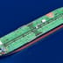 An aerial view of a large green oil tanker sailing across deep blue ocean water.