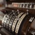 An extreme close-up of the brass mechanical keys and levers on a vintage cash register.