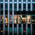 The illuminated windows of a modern corporate office building seen from the exterior at night.