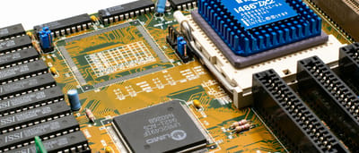 A close-up view of an Intel microchip and electronic components on a bright computer motherboard.