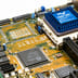 A close-up view of an Intel microchip and electronic components on a bright computer motherboard.