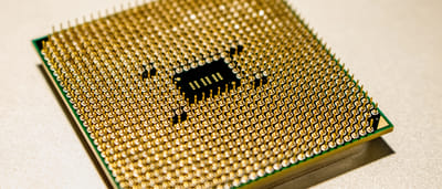 A close-up view of the golden pins on the underside of a modern microprocessor chip.