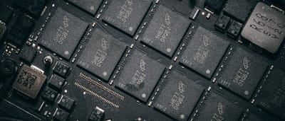 A detailed macro view of modern semiconductor chips and electronic components mounted on a sleek, dark circuit board.