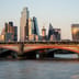 The modern skyscraper skyline of the City of London financial district glowing in warm sunlight.