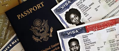 A United States passport resting next to official US visa documents and financial cards.