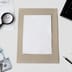 A blank white document sits on a desk surrounded by a stock chart, a magnifying glass, a calculator, and hundred dollar bills.