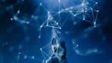 A robotic hand reaching upward to touch a glowing digital network against a deep blue background.