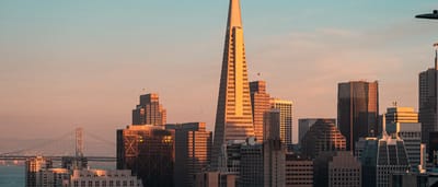 The Transamerica Pyramid stands prominently in the San Francisco skyline during a warm golden sunset.