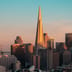 The Transamerica Pyramid stands prominently in the San Francisco skyline during a warm golden sunset.