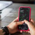 A person holds a smartphone displaying a green upward trend on a modern investing application.