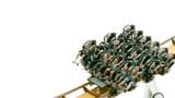 Passengers scream as they plunge down a steep roller coaster drop against a stark white sky.