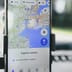 A close-up of a smartphone on a car mount displaying the Google Maps application and tracking a location.