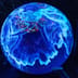 A glowing blue digital projection of the Earth covered in data points in a dark room.