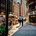 Pedestrians and street vendors walk past the exterior of the Nasdaq MarketSite building in a sunny Times Square.