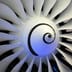 Close-up of a modern jet engine turbine with pristine white blades and a spiral center.
