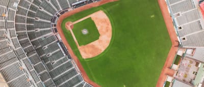 A top-down aerial view of an empty major league baseball stadium and its green diamond.